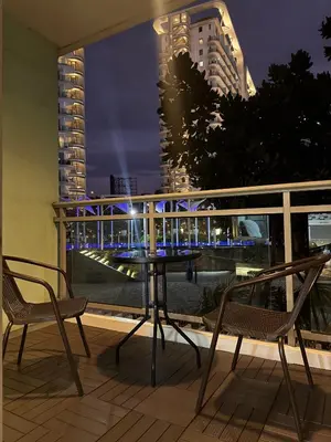 a table and chairs on a balcony with a view of a city at Azure Urban Resort-The Rustic Escape in Manila