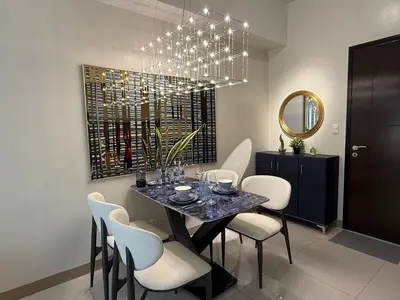 a dining room with a table with chairs and a chandelier at Playful 1BR With Magnificant Bayview Garden View Near Okada, Solaire, Aiports in Manila