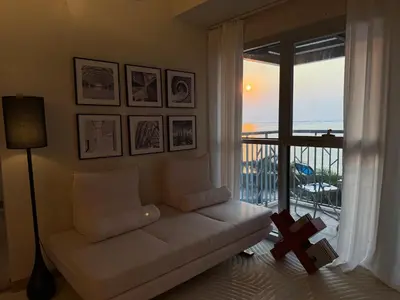 a living room with a couch and a large window at Playful 1BR With Magnificant Bayview Garden View Near Okada, Solaire, Aiports in Manila