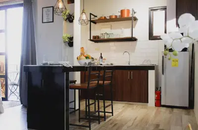 a kitchen with a black counter and a refrigerator at Modern Chic Retreat in Antipolo