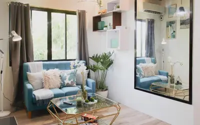 a living room with a blue couch and a glass table at Modern Chic Retreat in Antipolo