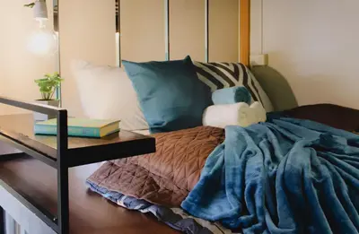 a bedroom with a bed and a table with books at Modern Chic Retreat in Antipolo
