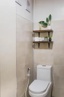 a bathroom with a white toilet and some plants at Modern Chic Retreat in Antipolo
