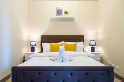 a bedroom with a bed with a stuffed animal on it at Uptown Parksuites Sky Garden Flr Bright Airy 2 BR balcony in Manila