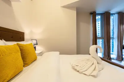 a bedroom with a white bed with a swan on it at Uptown Parksuites Sky Garden Flr Bright Airy 2 BR balcony in Manila