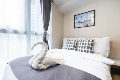 a swan toy on a bed in a bedroom at Uptown Parksuites Sky Garden Flr Bright Airy 2 BR balcony in Manila