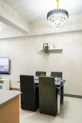 a dining room with a table and a chandelier at Uptown Parksuites Sky Garden Flr Bright Airy 2 BR balcony in Manila