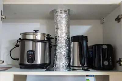 a kitchen shelf with a slow cooker and a blender at Uptown Parksuites Sky Garden Flr Bright Airy 2 BR balcony in Manila