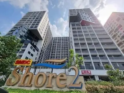 a store sign in front of two tall buildings at Shore 2 Tower 3 1BR 15th Floor Near SMX MOA in Manila
