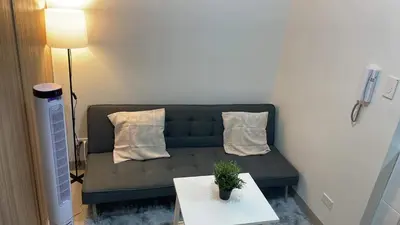 a living room with a couch and a table at Shore 2 Tower 3 1BR 15th Floor Near SMX MOA in Manila