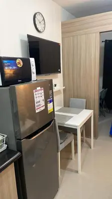 a kitchen with a table and a refrigerator and a clock at Shore 2 Tower 3 1BR 15th Floor Near SMX MOA in Manila
