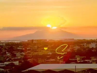 a sunset over a city with a mountain in the background at Azure staycation by Scarlet Suites in Manila