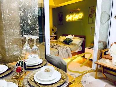 a living room with a table with dishes on it at Azure staycation by Scarlet Suites in Manila