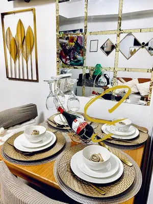 a dining room table with plates and dishes on it at Azure staycation by Scarlet Suites in Manila