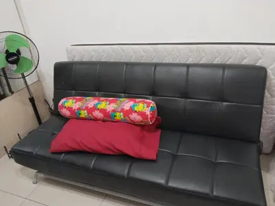a black leather couch with two pillows on it at MOA Sea Residences Condo in Manila