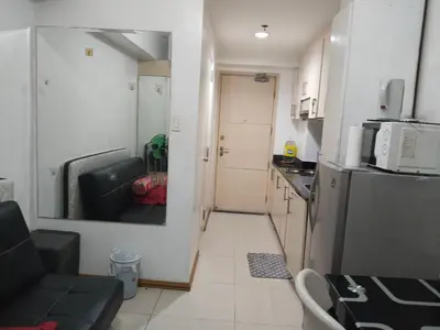 a small kitchen with a couch and a refrigerator at MOA Sea Residences Condo in Manila