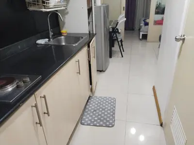 a kitchen with a sink and a black counter top at MOA Sea Residences Condo in Manila