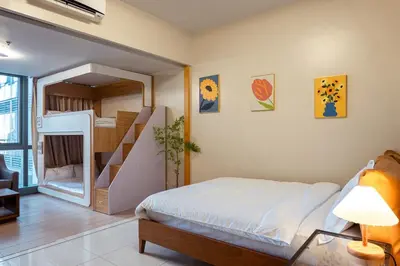 a bedroom with a bunk bed and a staircase at Uptown BGC Spacious Unit - 1 Queen bed and Bunkbed in Manila
