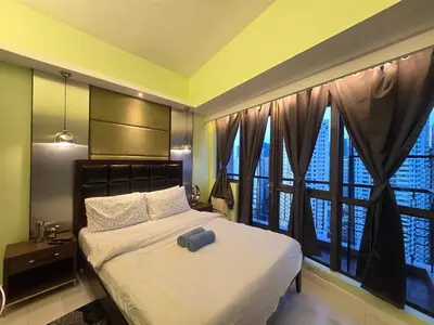 a bedroom with a bed and a large window at KL Tower Cosy Studio with City and Park View in Manila