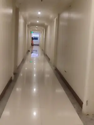 a long hallway with white walls and a person in the distance at BS651 Room with Balcony and free pool in Manila