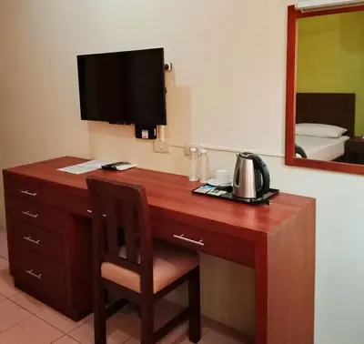 a desk in a hotel room with a television on it at Joyce Apartelle Mandaluyong in Manila