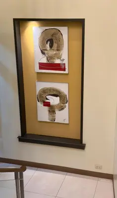 a framed picture on a wall with paintings at Joyce Apartelle Mandaluyong in Manila