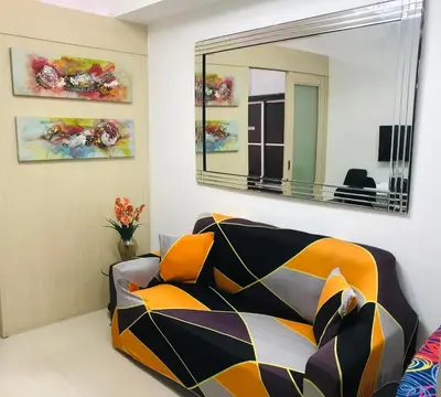 a living room with a couch and a mirror at Sea Residences-Booking Reservation in Manila