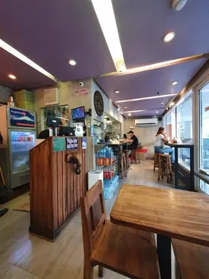 a restaurant with a table and chairs and people sitting at tables at Sea Residences-Booking Reservation in Manila