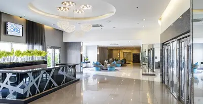 a lobby of a hotel with people sitting on couches at Sea Residences-Booking Reservation in Manila