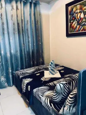 a room with a bed with a blue curtain at Sea Residences-Booking Reservation in Manila