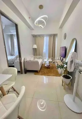 a living room with a couch and a table at Staycation in Manila near NAIA Airport in Manila