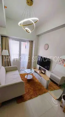a living room with a couch and a chandelier at Staycation in Manila near NAIA Airport in Manila