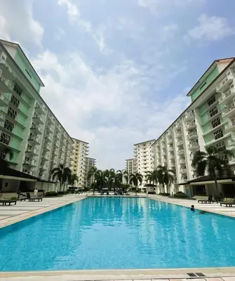 a large swimming pool in the middle of two buildings at Staycation in Manila near NAIA Airport in Manila