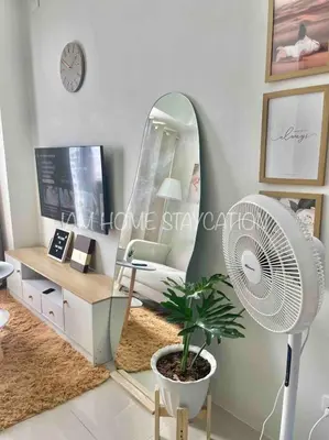 a living room with a fan and a mirror at Staycation in Manila near NAIA Airport in Manila