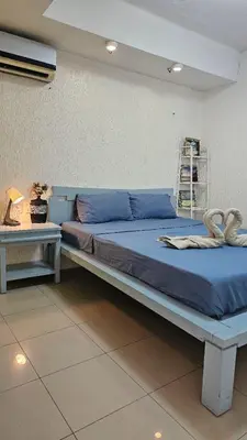 a bed with blue sheets in a room at Marbella Tower 2 in Manila