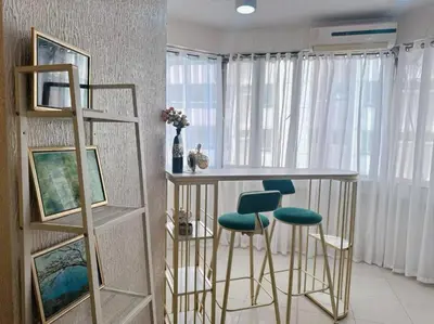 a kitchen with a table and stools in a room at Marbella Tower 2 in Manila