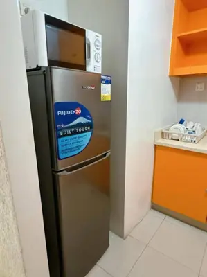 a kitchen with a stainless steel refrigerator with a sign on it at Marbella Tower 2 in Manila