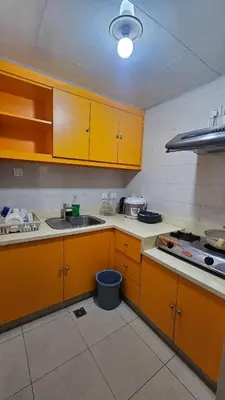 a kitchen with yellow cabinets and a sink at Marbella Tower 2 in Manila