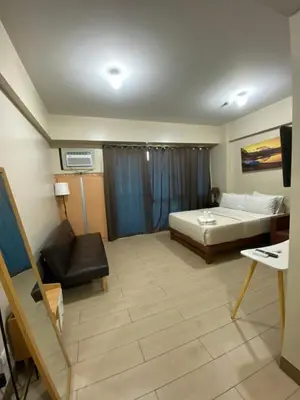 a hotel room with a bed and a couch and a television at the palm tree villas by kath in Manila