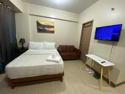 a hotel room with a bed and a flat screen tv at the palm tree villas by kath in Manila