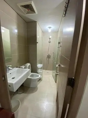 a bathroom with a sink and a toilet and a shower at the palm tree villas by kath in Manila