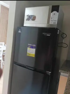 a microwave sitting on top of a refrigerator at JRM Staycation Naia T3 C66E in Manila