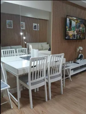 a dining room with a white table and chairs at JRM Staycation Naia T3 C66E in Manila