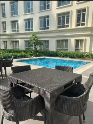 a table and chairs next to a swimming pool at JRM Staycation Naia T3 C66E in Manila