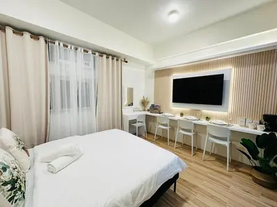a bedroom with a bed and a desk and a television at Getaway Haven at Southwoods, Biñan with Fast Internet in Biñan