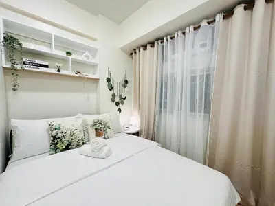 a bedroom with a white bed with a window at Getaway Haven at Southwoods, Biñan with Fast Internet in Biñan
