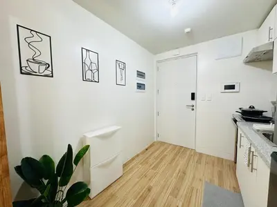a kitchen with white walls and a wooden floor at Getaway Haven at Southwoods, Biñan with Fast Internet in Biñan