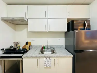 a kitchen with a sink and a refrigerator at Getaway Haven at Southwoods, Biñan with Fast Internet in Biñan