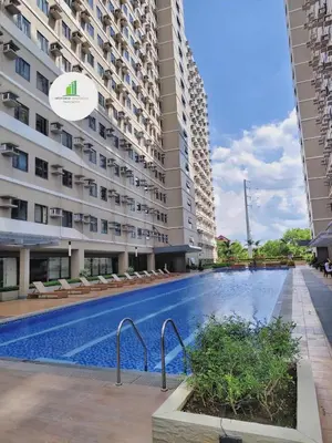 a swimming pool in front of a building at Affordable Staycation in Dasma Green 2 Residence in Dasmariñas