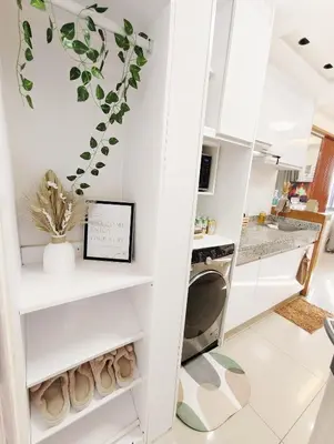 a kitchen with white cabinets and a plant on the wall at Affordable Staycation in Dasma Green 2 Residence in Dasmariñas